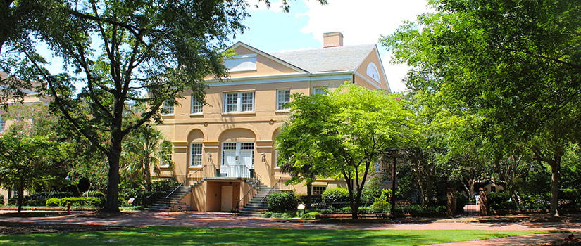 McCutchen House sits on the edge of the lush green lawn and old oak trees of the Horseshoe, the historic center of the University.