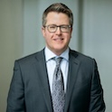 man in gray suit smiling