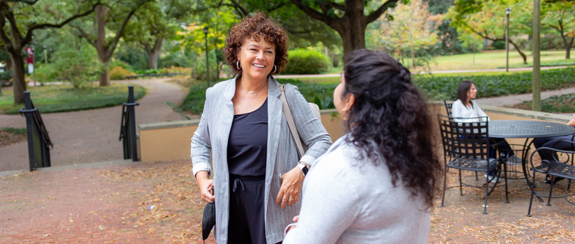 Professor Roberts conversing with a student in front of Barnwell College