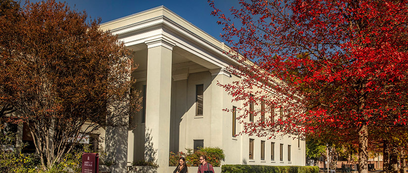 Wardlaw College on a sunny day. Two people are walking past in foreground.