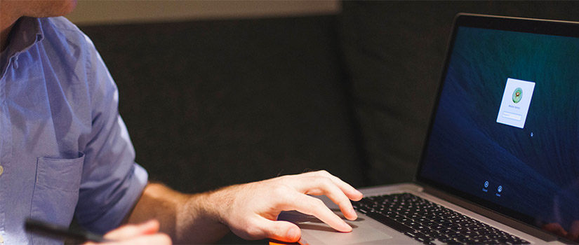 man logging in to laptop