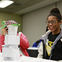 girl looks at paper tower