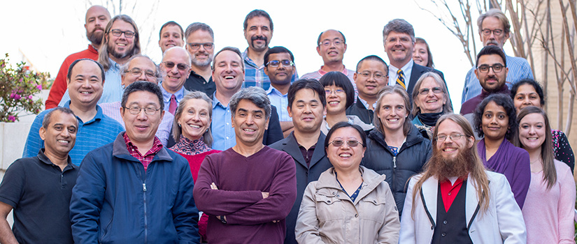 large group of department faculty stand on the steps outside of the innovation center