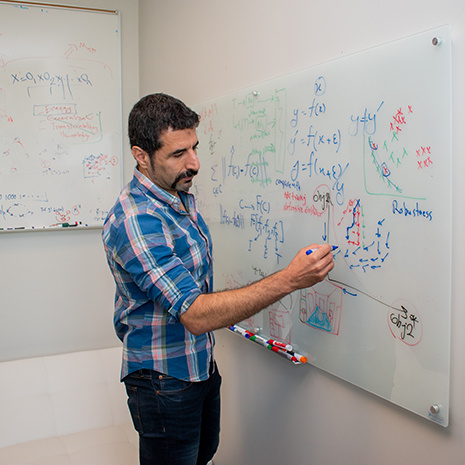 Pooyan writes on a whiteboard.