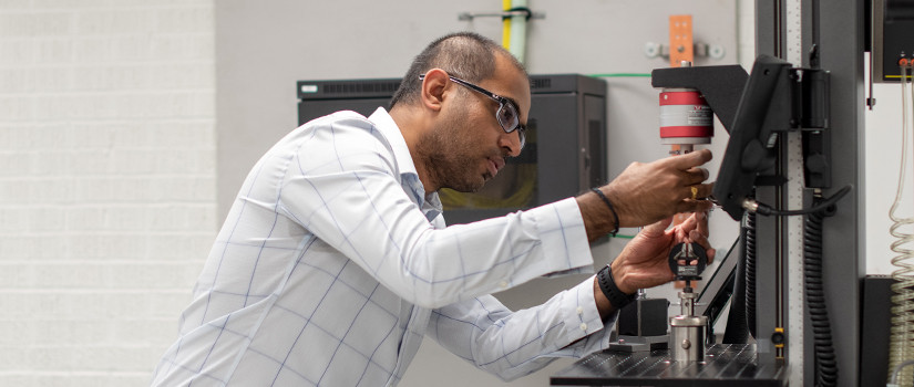 Mani works on a machine in his lab.