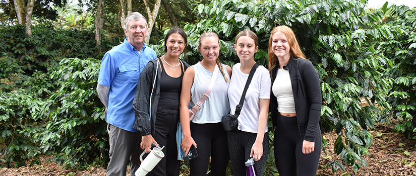 Students and an instructor pose for a photo outside a cafe in the Galapagos.