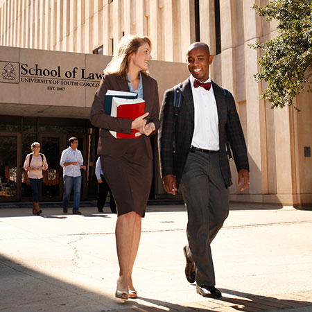 A white female student and black male student talk as they walk out of the doors of one of South Carolina Law's previous buildings.