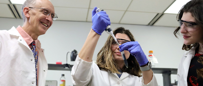 Wyatt with two students in lab