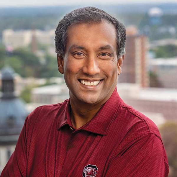 Deepal Eliatamby stands in his office with the statehouse dome in the background