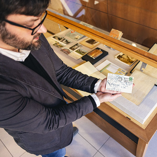 Michael Weisenburg holds up a postcard that is part of the Gatsby exhibit.