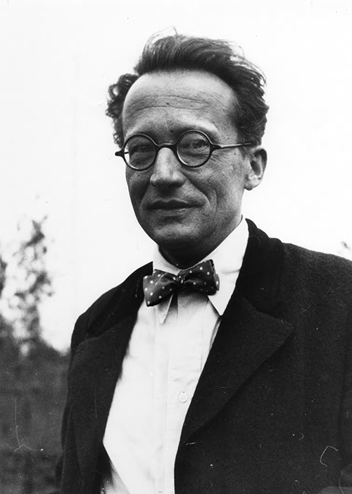 Black-and-white photo of Erwin Schrodinger in suitcoat and bowtie wearing eyeglasses.